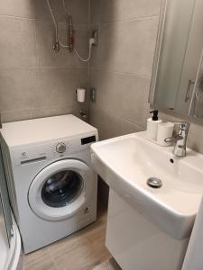 a bathroom with a washing machine and a sink at Oldie Apartment Šamorín in Šamorín