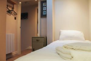 a bedroom with a white bed with towels on it at Wharmton luxury apartment in Dobcross