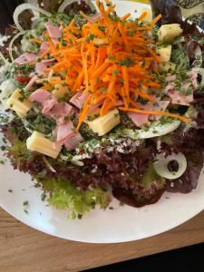 a salad with cheese and other vegetables on a plate at Buddes Wirtshaus in Drolshagen
