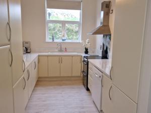 a white kitchen with a sink and a window at Beach House in Duncannon