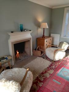 a living room with a fireplace and two chairs at Riverside House in Thornhill