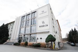 a white building with a sign on the side of it at Apartmány Jako doma in Plzeň