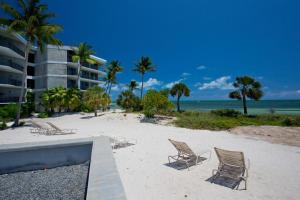 una spiaggia con sedie e un edificio e l'oceano di Casa Pap Del Mar a Key West