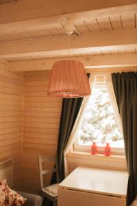 a light hanging over a table in a room with a window at ZlatAir Eco Chalet in Nova Varoš