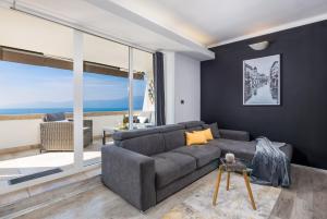 - un salon avec un canapé et une grande fenêtre dans l'établissement Lux Apartment SKY VIEW, à Rijeka