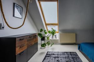 un dormitorio en el ático con una gran ventana y una alfombra en FeWo Am Grassi Museum, en Leipzig