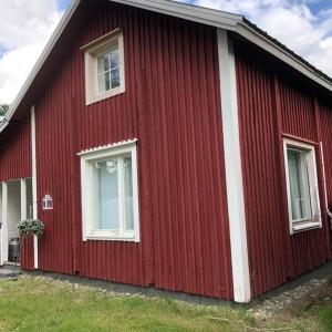 una casa roja con dos ventanas en el lateral. en Villa Oiva, en Ylihärmä