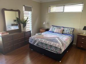 um quarto com uma cama e um espelho grande em Cheerful city house em Cairns