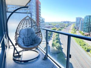 a swing on a balcony with a view of a city at Exquisite Condo By Exhibition Place Downtown Toronto in Toronto