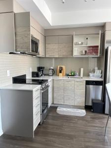 una cocina con electrodomésticos de acero inoxidable y armarios de madera en Exquisite Condo By Exhibition Place Downtown Toronto en Toronto