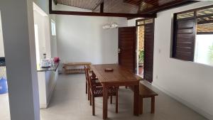 a dining room with a wooden table and chairs at Casa aconchegante com piscina e muito espaço verde in Aracaju