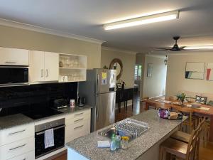 a kitchen with a refrigerator and a counter top at Cheerful city house in Cairns