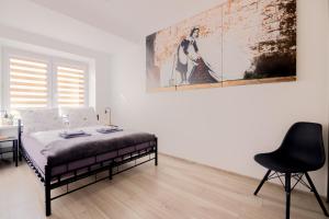 a bedroom with a bed and a desk and a chair at THE SOUL of Nowa Huta - free garage in Kraków