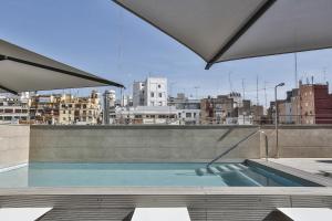 a swimming pool on the roof of a building at Vincci Mercat in Valencia