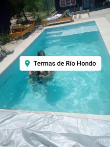 una persona nadando en una piscina con un texto que lee temammers de ric en La Rosadita en Termas de Río Hondo