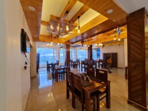 a dining room with tables and chairs and a television at Mount heaven in Kandāghāt