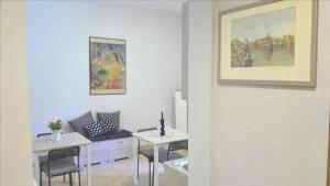 ローマにあるMaria's Roomsのリビングルーム(テーブル、椅子、絵画付)