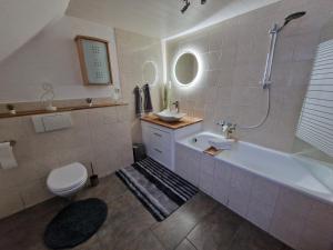 bagno con vasca, lavandino e servizi igienici di Ferienwohnung Haus Sonnenblick a Burkhardtsdorf
