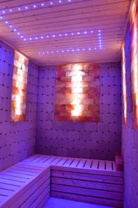 a sauna with purple lights on a brick wall at Hotel Superski in Cavnic