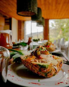 um prato branco com um ananás sobre uma mesa em Nalanda Casa de Montaña em Patate