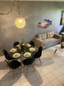 uma sala de estar com uma mesa e cadeiras e um sofá em Duplex em condomínio no Barra Mar em Barra de São Miguel