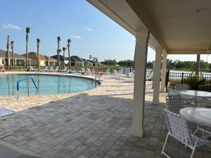 a swimming pool with tables and chairs next to a resort at Relaxing, Golf, Pools, Hiking, events in Wildwood