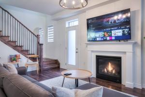 a living room with a couch and a fireplace at Modern Comforts and Spacious Living 4B/3.5 Bath in Pickering