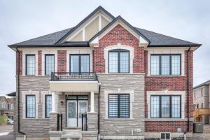 a red brick house with a black roof at Modern Comforts and Spacious Living 4B/3.5 Bath in Pickering
