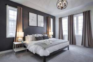 a bedroom with a bed and two lamps and windows at Modern Comforts and Spacious Living 4B/3.5 Bath in Pickering