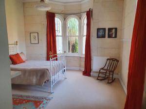 a bedroom with a bed and a large window at Braemar House in Oamaru