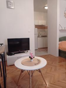 Una sala de estar con una mesa y un televisor. en Alina centar, en Novigrad Istria