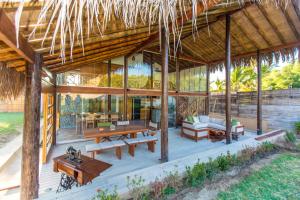 einen Pavillon mit einem Tisch und Bänken auf einer Terrasse in der Unterkunft Zuzu Vichayito Casa para 9 con piscina in Los Órganos