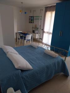 a bedroom with a blue bed with pillows on it at Appartamento Memorie in Otranto