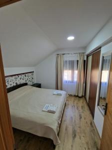 a hotel room with a bed and a window at Dani apartment in Vrdnik
