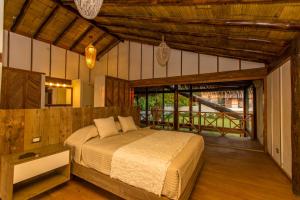 a bedroom with a bed and a large window at Zuzu Vichayito Casa para 9 con piscina in Los Órganos