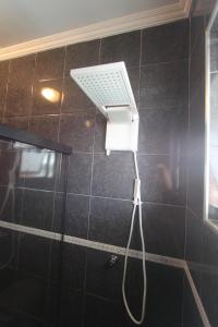 a shower with a shower head in a bathroom at Estação Brotense - Casa com piscina e fogueira exclusiva in Brotas
