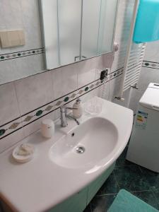 uma casa de banho com um lavatório branco e um espelho. em Appartamento Memorie em Otranto