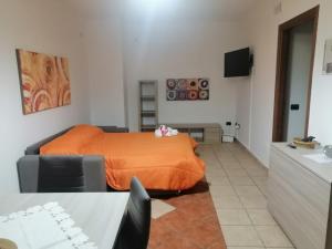 a bedroom with a bed with an orange blanket at Sweet Home La Ville in Caserta