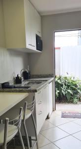 una cucina con due sedie e un bancone con lavandino di Quarto Jaraguá/São Luís a Jaraguá do Sul