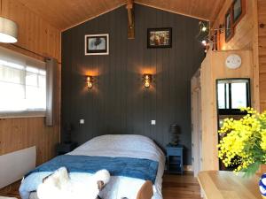 un dormitorio con una cama con un perro sobre ella en Gîte de l'océan, 3 étoiles - Les cabanes océanes, Montalivet, en Vendays-Montalivet
