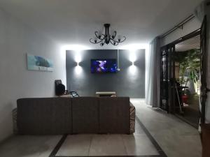 sala de estar con sofá y TV en la pared en Residence YG, en Palmyre