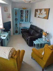 sala de estar con sofá y mesa en La Jacaranda, en Casarabonela