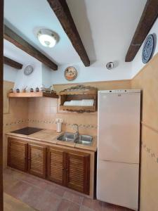 a kitchen with a white refrigerator and a sink at Vivienda Vacacional VELEFIQUE in Velefique +16 photos