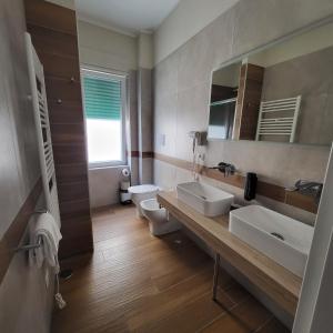 a bathroom with two sinks and a toilet and a mirror at B&B Salerno Urban Suite 57 in Salerno +47 photos