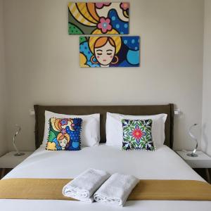 uma cama com duas almofadas e um quadro na parede em B&B Salerno Urban Suite 57 em Salerno