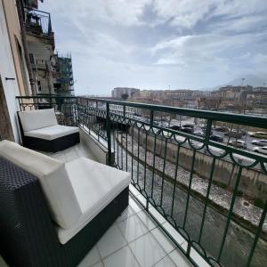 a balcony with two chairs and a view of a river at B&B Salerno Urban Suite 57 in Salerno