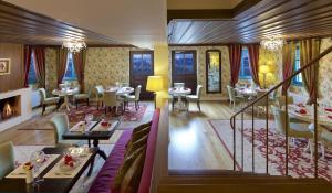 un restaurante con mesas y sillas y una chimenea en Zagori Suites Luxury Residences, en Vitsa