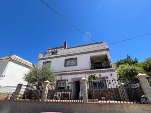 a white house with a fence in front of it at Vivienda Vacacional VELEFIQUE in Velefique