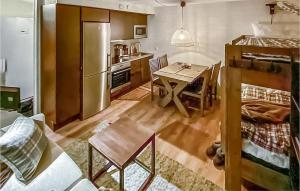 a kitchen and dining room with a table and a refrigerator at Stunning Apartment In Slen With Kitchen in Sälen