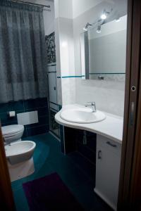 een badkamer met een witte wastafel en een toilet bij Casa Diamante in San Vito lo Capo